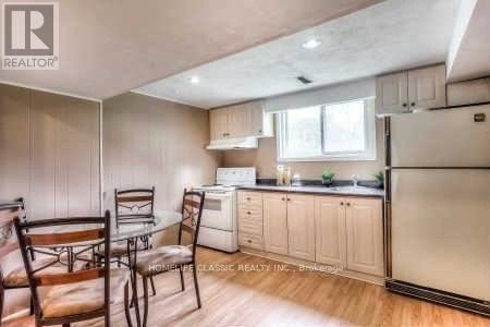 A kitchen with white cabinets and a black fridge.