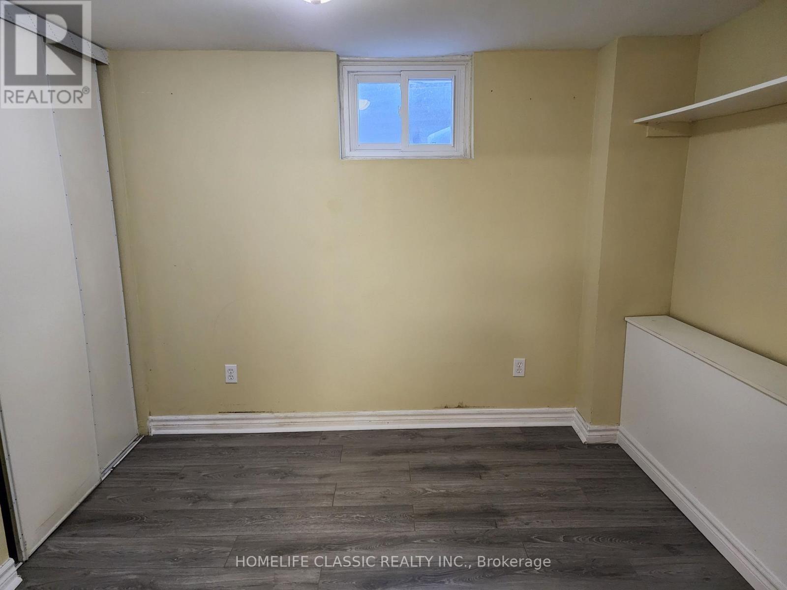 A room with a window and wooden flooring.