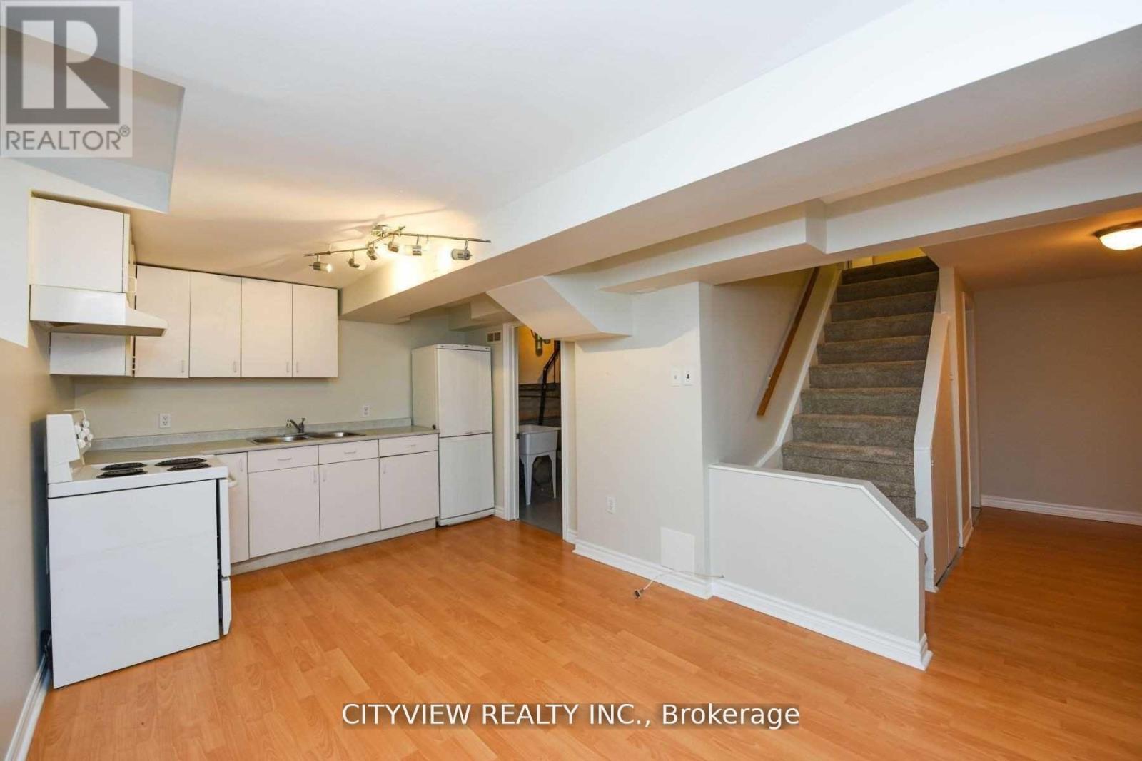 A real estate listing photo of a kitchen and living room.