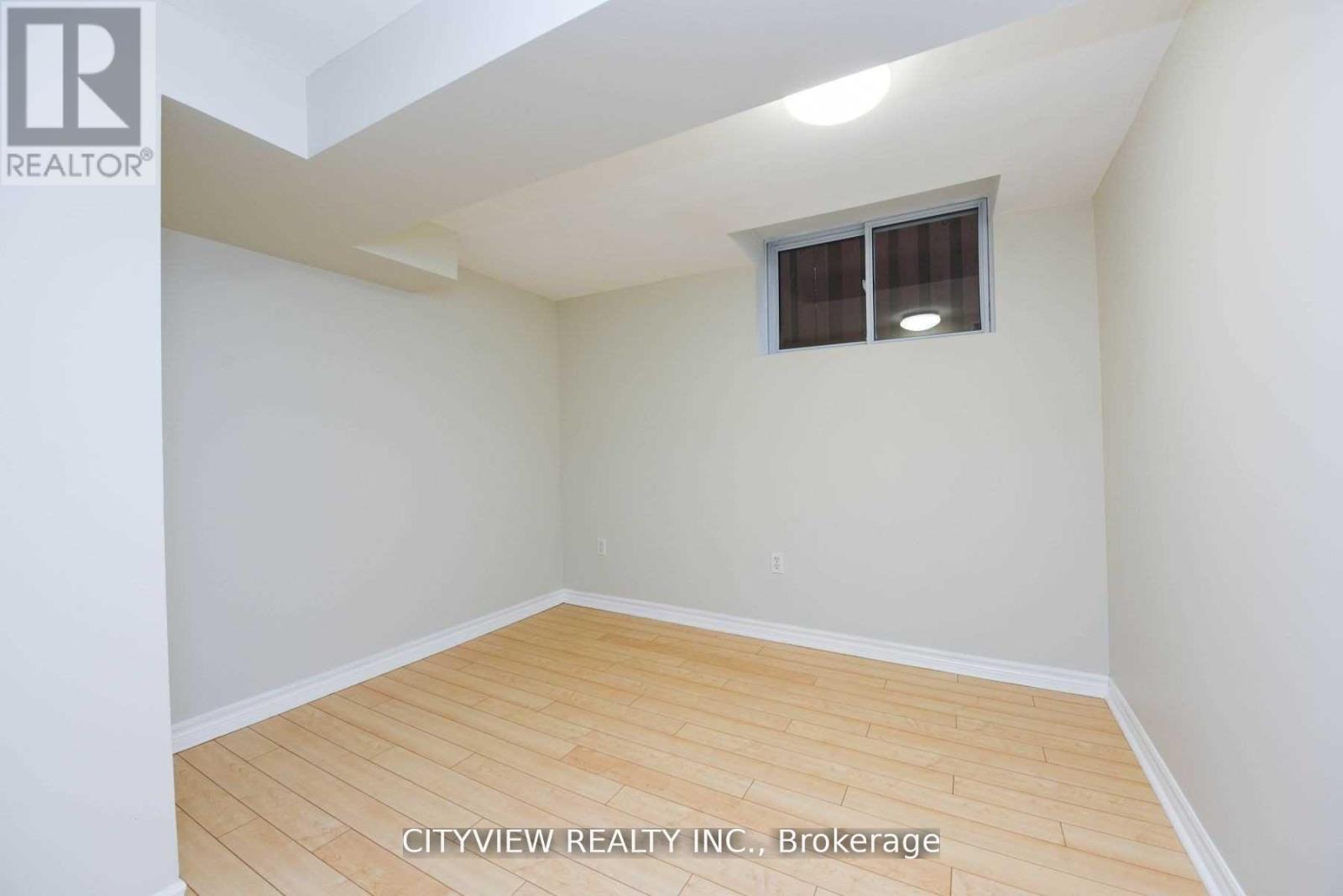 A room with a window and wooden flooring.