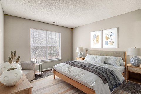 A bedroom with a large bed and a vase on a table.