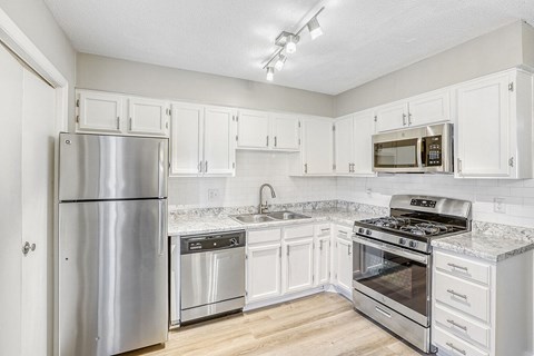 A kitchen with white cabinets and stainless steel appliances.