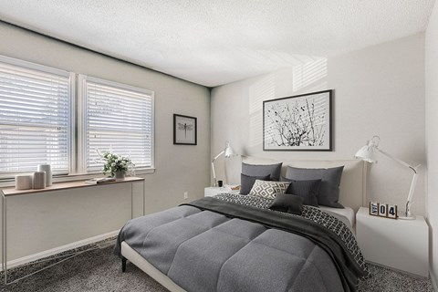 A bedroom with a large bed and a window with blinds.