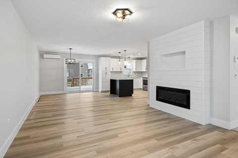 A modern living room with a fireplace and hardwood floors.