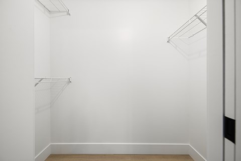 A white wall with a shelf and a light fixture.