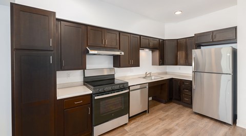 A kitchen with dark wood cabinets and stainless steel appliances.