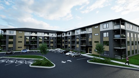 A modern apartment complex with a parking lot in front.
