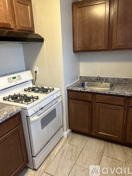 A kitchen with a white stove and brown cabinets.