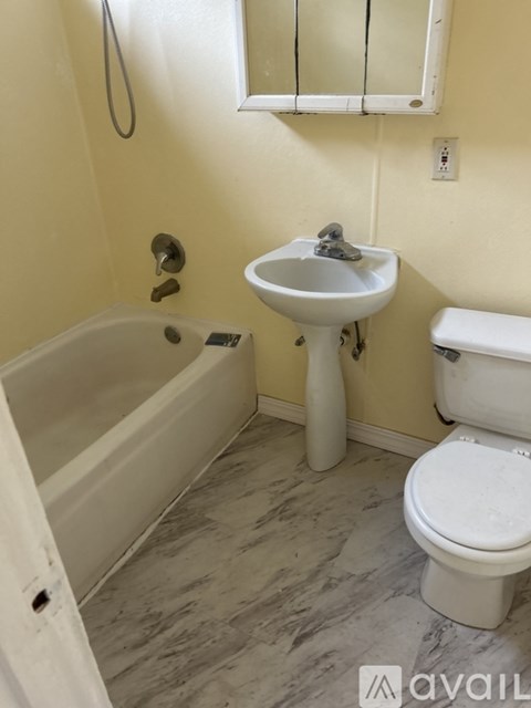 A bathroom with a toilet, sink, and bathtub.