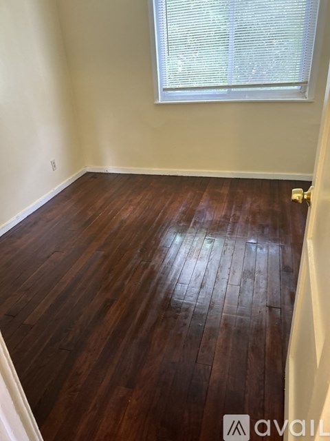 A room with wooden flooring and a window.