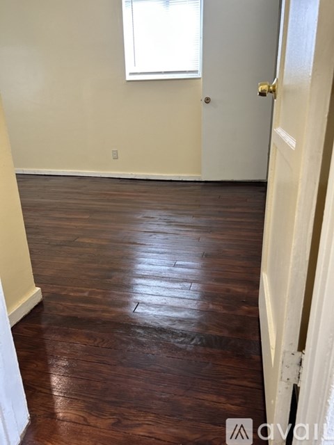 A room with a wooden floor and a white door.