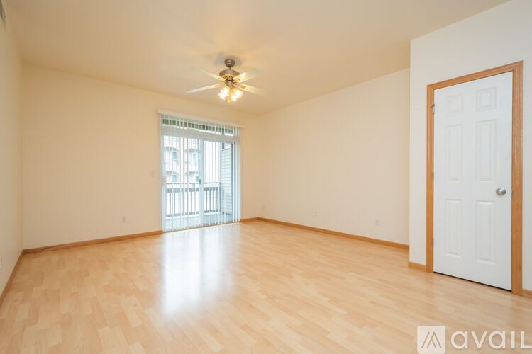 A room with wooden flooring and a ceiling fan.