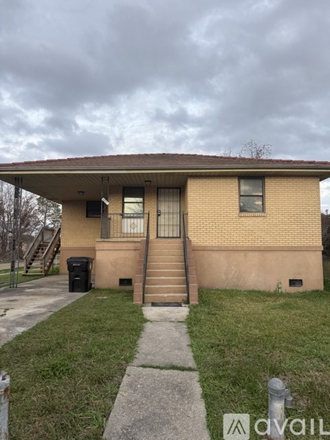 A house with a brown brick exterior and a red roof.