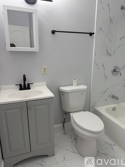 A white toilet sits next to a sink in a bathroom.
