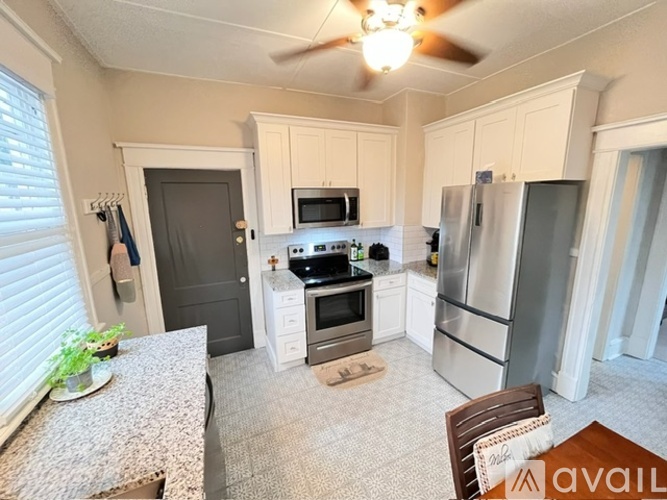 A kitchen with a refrigerator, oven, and microwave.