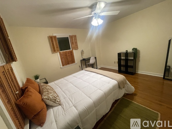 A bedroom with a white bed and brown pillows.