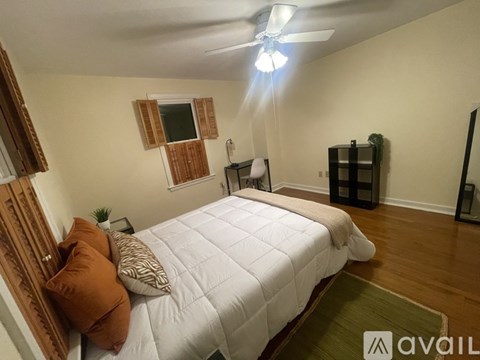 A bedroom with a white bed and brown pillows.
