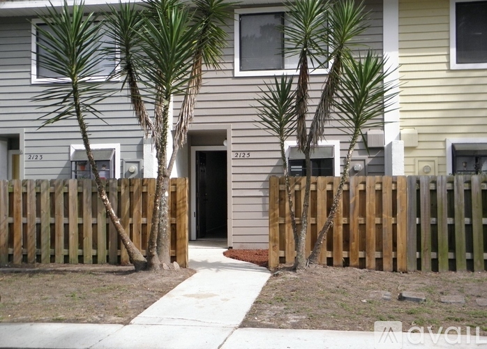A house numbered 2125 is shown with a wooden fence and a tree in front.