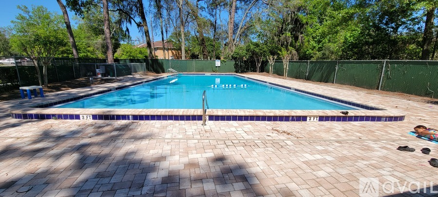 A rectangular pool with a blue tiled edge and a purple tiled floor.