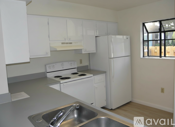 A kitchen with white cabinets and a stainless steel sink.