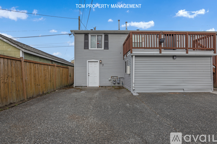 A grey house with a wooden fence and a garage door.