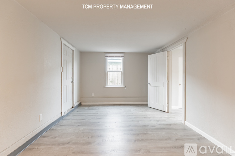 A spacious room with wooden flooring and a window is available for rent.