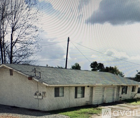 A house with a grey roof and white walls is shown with a striped pattern overlay.
