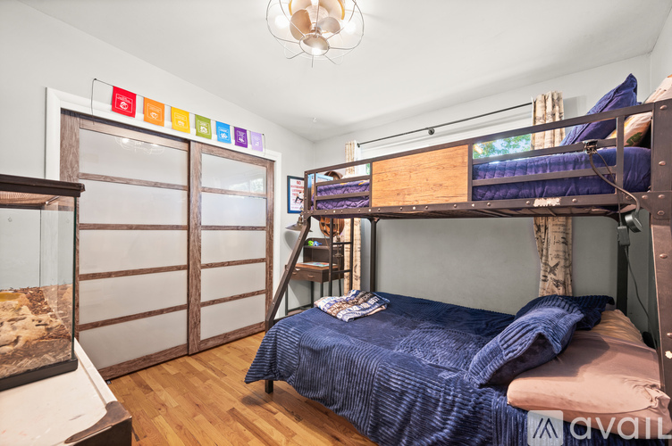 A bedroom with a bunk bed and a blue bedspread.