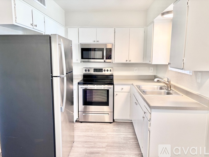 A kitchen with white cabinets and stainless steel appliances.