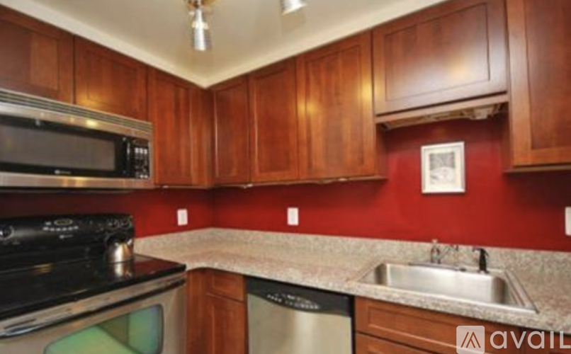 A kitchen with wooden cabinets and a stainless steel dishwasher.