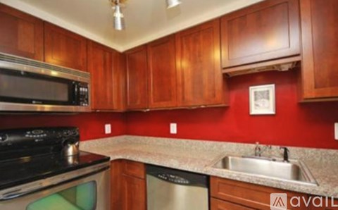 A kitchen with wooden cabinets and a stainless steel dishwasher.