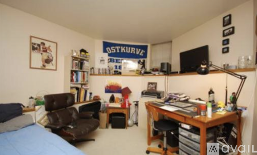 A room with a bed, desk, and a chair.