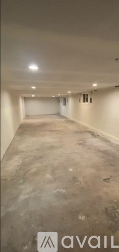 A spacious empty room with a concrete floor and white walls.