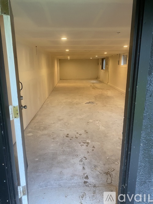 A long, empty hallway with a door on the left and a window on the right.