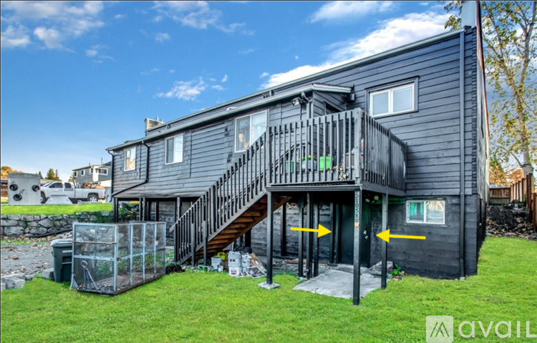 A modern house with a black exterior and a large deck.