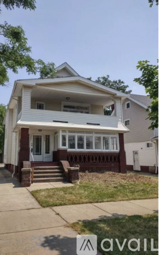 A two-story house with a front porch and a garage door.
