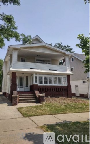 A two-story house with a front porch and a garage door.