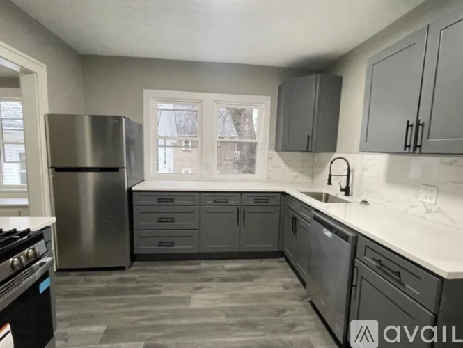 A kitchen with a stainless steel refrigerator, sink, and cabinets.