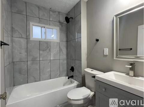 A bathroom with a white tub, toilet, and sink.