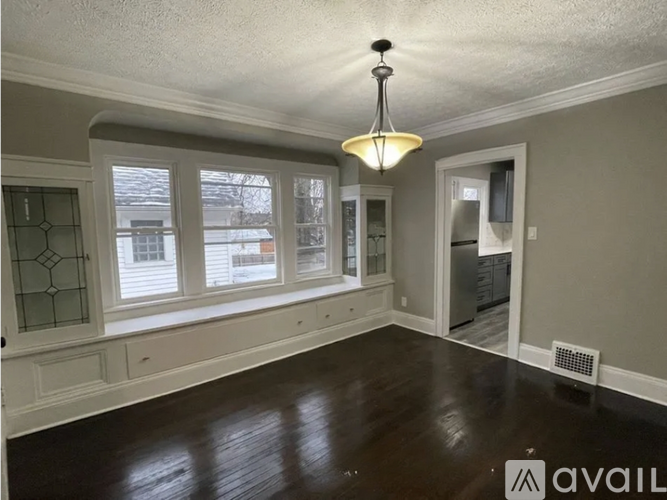 A room with a wooden floor and a chandelier hanging from the ceiling.