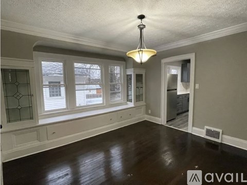A room with a wooden floor and a chandelier hanging from the ceiling.