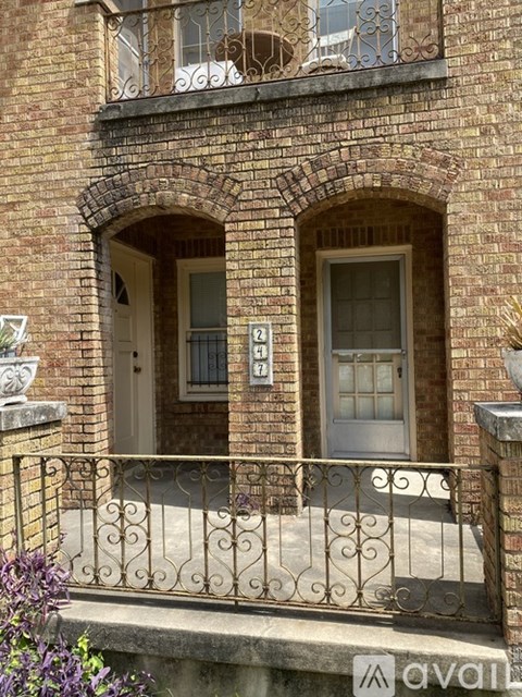 A brick building with a balcony and a window.