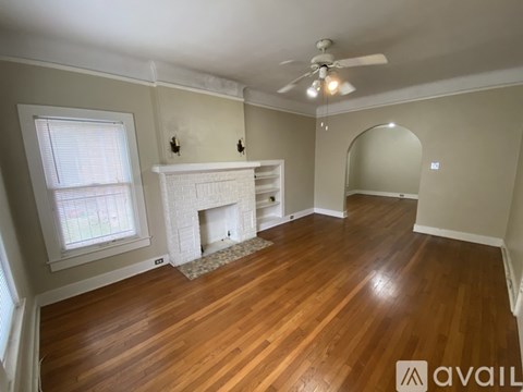 A room with a fireplace and a ceiling fan.