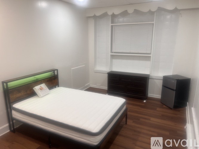 A bedroom with a bed, nightstand, and a cabinet.