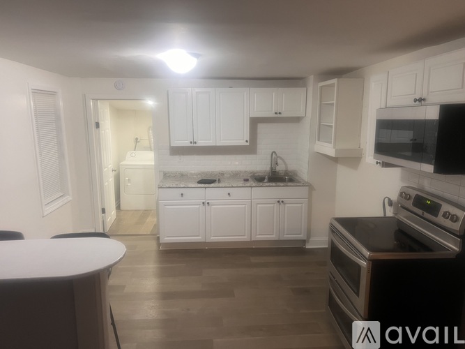 A kitchen with white cabinets and a black stove top oven.
