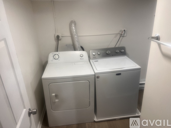 A white dryer and washer are sitting next to each other in a small room.