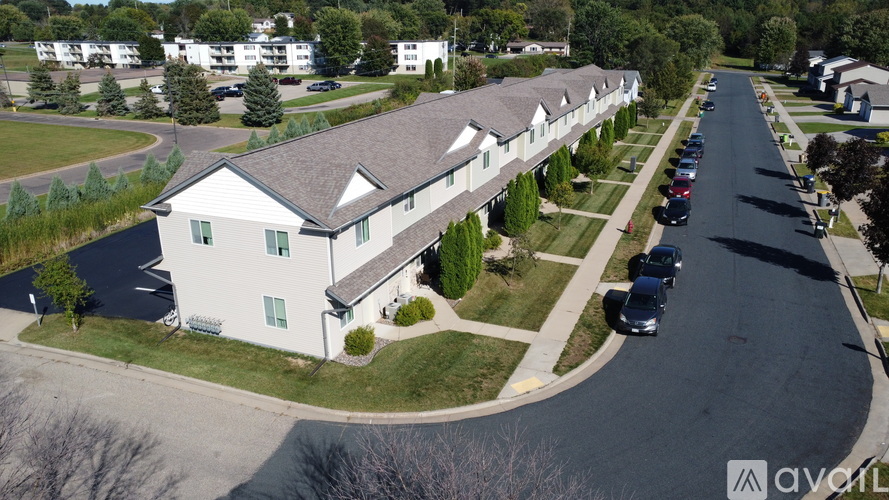 A row of houses with cars parked in front.