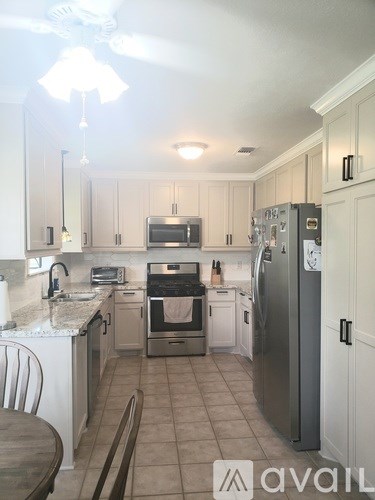 A kitchen with a refrigerator, oven, and microwave.