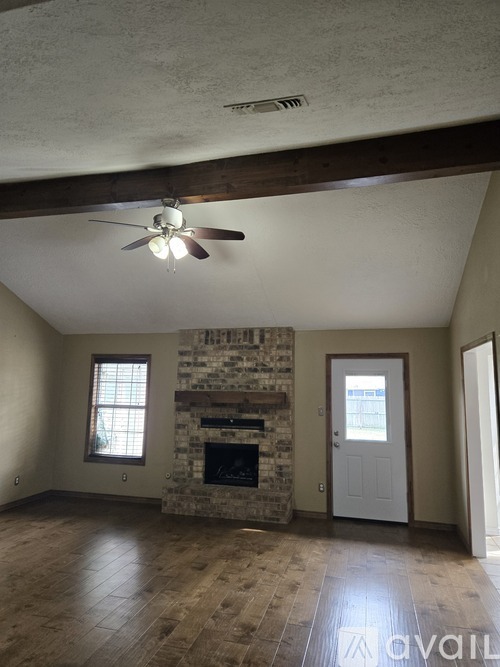 A living room with a fireplace and a ceiling fan.