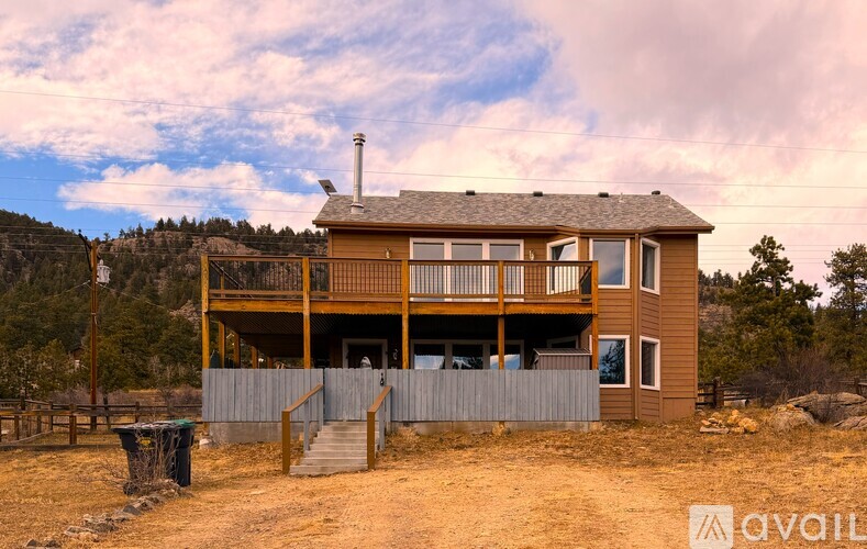 A wooden house with a balcony and a chimney is available for purchase.